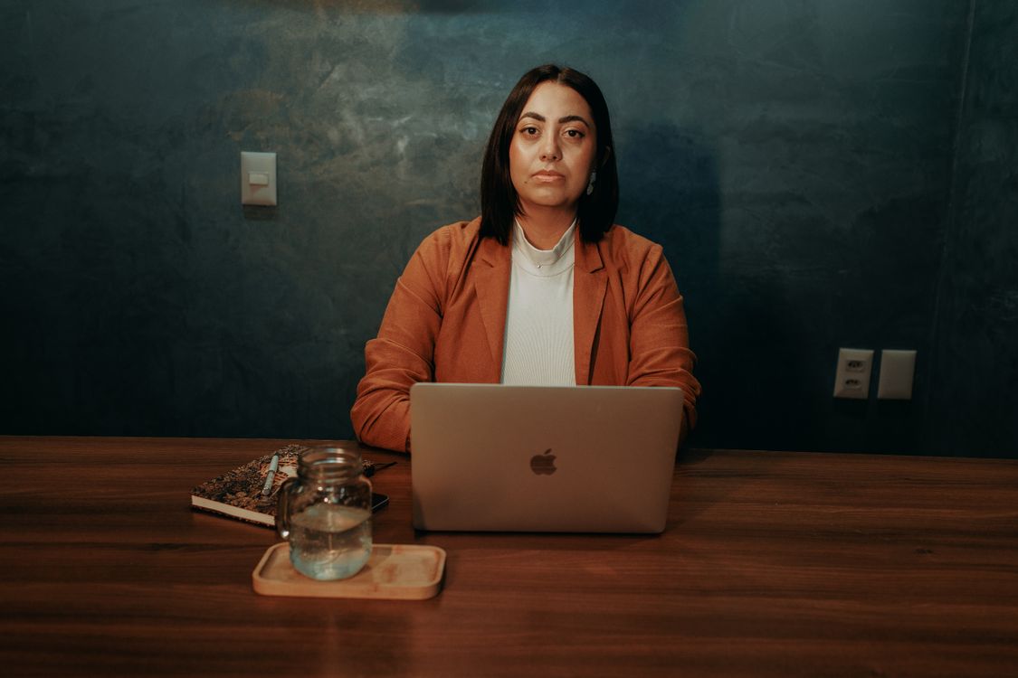 A professional woman working on a laptop in an office